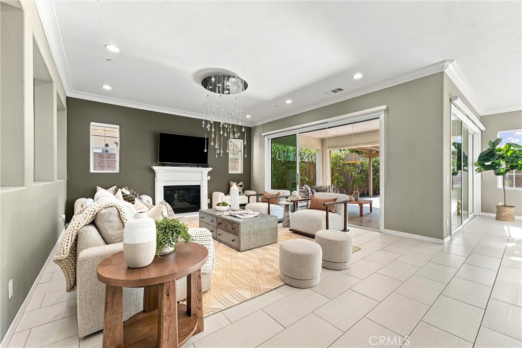 A spacious great room with fireplace, opens to a California room. - 104 Sparrow, Irvine CA 92618 - photo 15