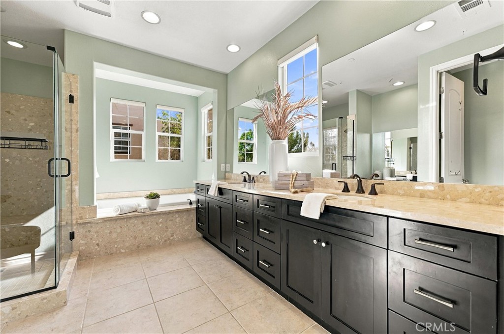 Primary bathroom with soaking tub, separate shower, and dual vanities. - 104 Sparrow, Irvine CA 92618 - photo 44