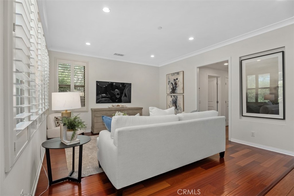 Spacious living room boasts crown molding, recessed lighting, hardwood floors and plantation shutters. - 117 Gemstone, Irvine CA 92620 - photo 6