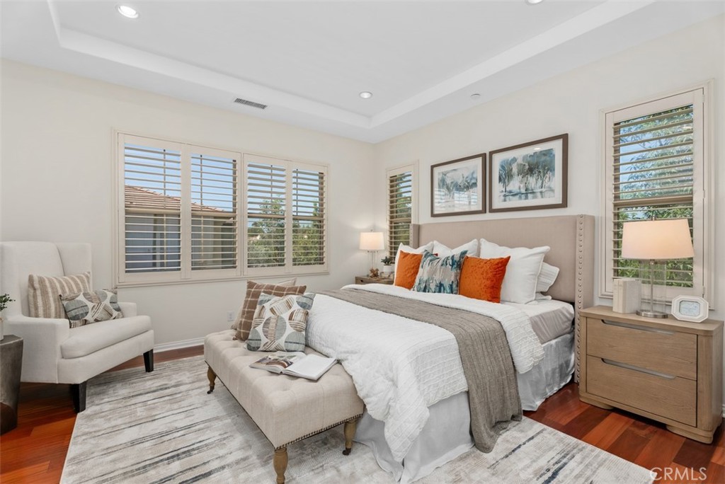 Bright primary bedroom with coffered ceiling and hardwood floors. - 117 Gemstone, Irvine CA 92620 - photo 13