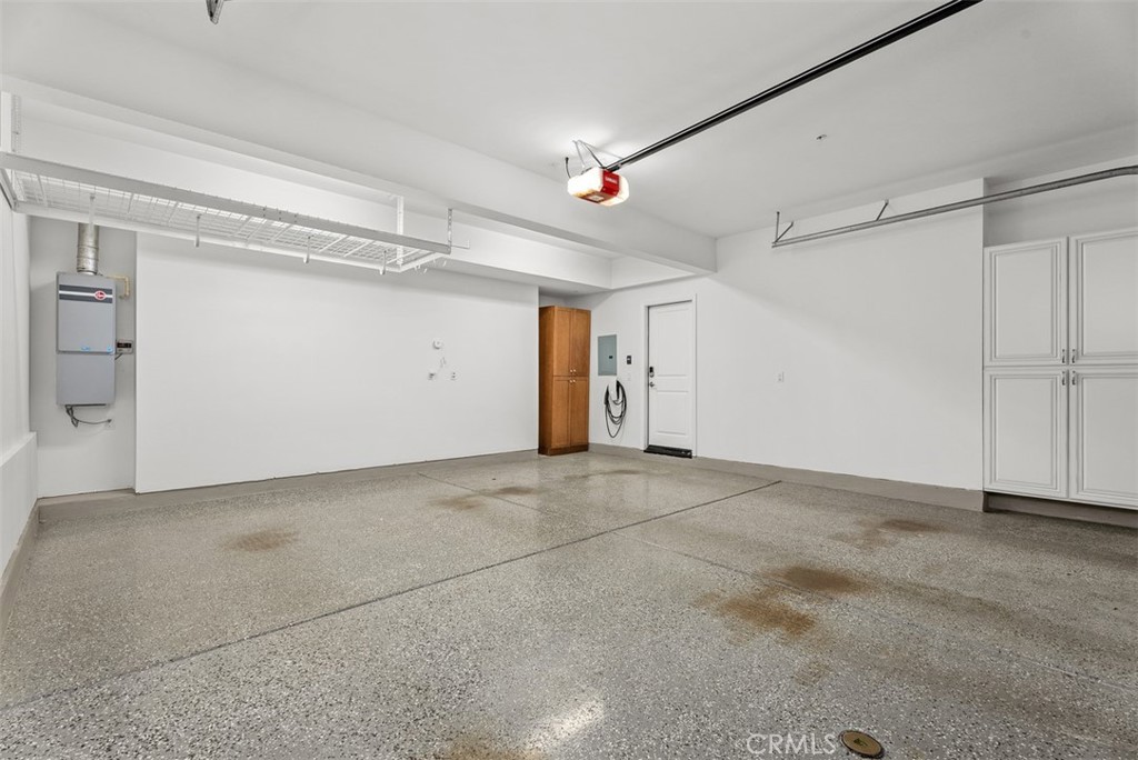 2-car garage with epoxi floors, Tesla charger, and custom storage. - 117 Gemstone, Irvine CA 92620 - photo 26