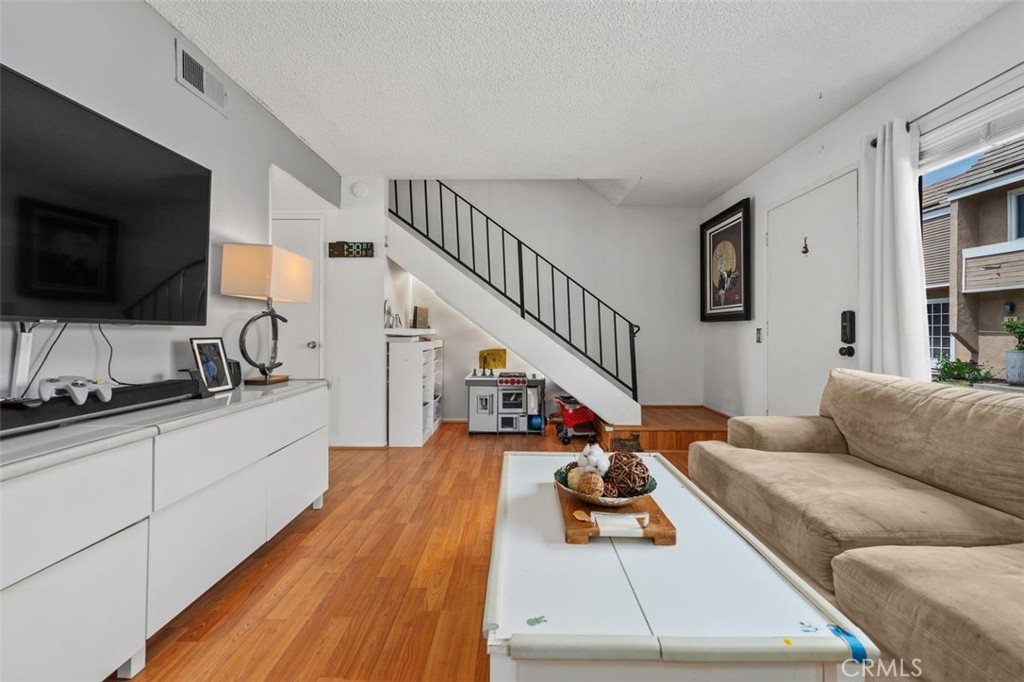 Living room with mirrored wall and view toward the staircase. - 14 Greenleaf, Irvine CA 92604 - photo 6