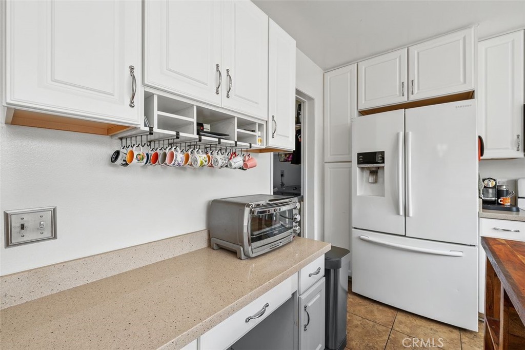 Updated kitchen with quartz countertops, white cabinetry, and included refrigerator. - 14 Greenleaf, Irvine CA 92604 - photo 15