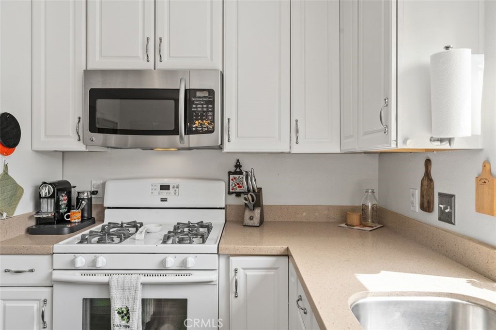Kitchen cooking area with gas range, built-in microwave, and additional​​‌​​​​‌​​‌‌​​‌‌​​‌‌​​‌​​​‌‌​‌​​​​‌‌​‌​​ cabinetr - 14 Greenleaf, Irvine CA 92604 - photo 16