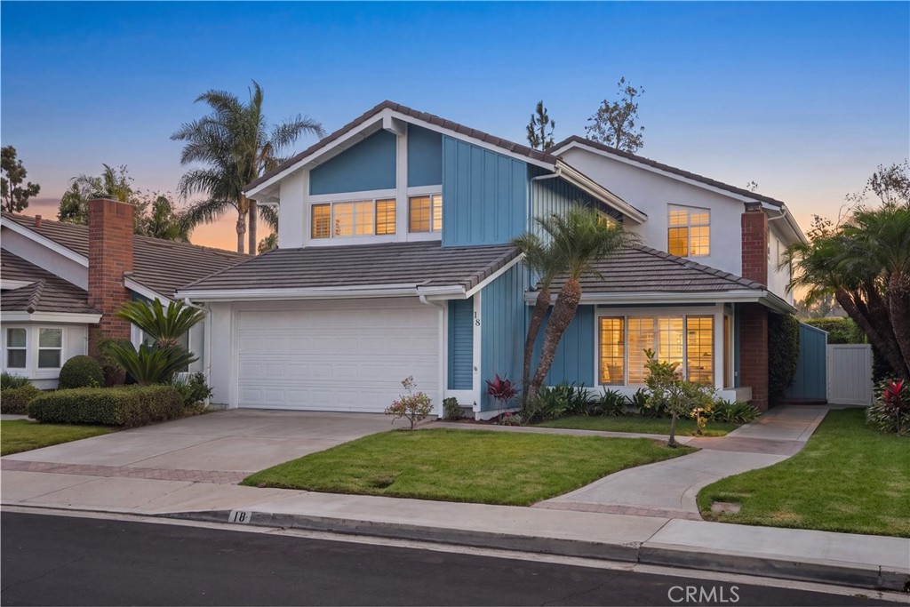 Twilight view of the two-story residence with landscaped front yard. - 18 Timbergate, Irvine CA 92614 - photo 1