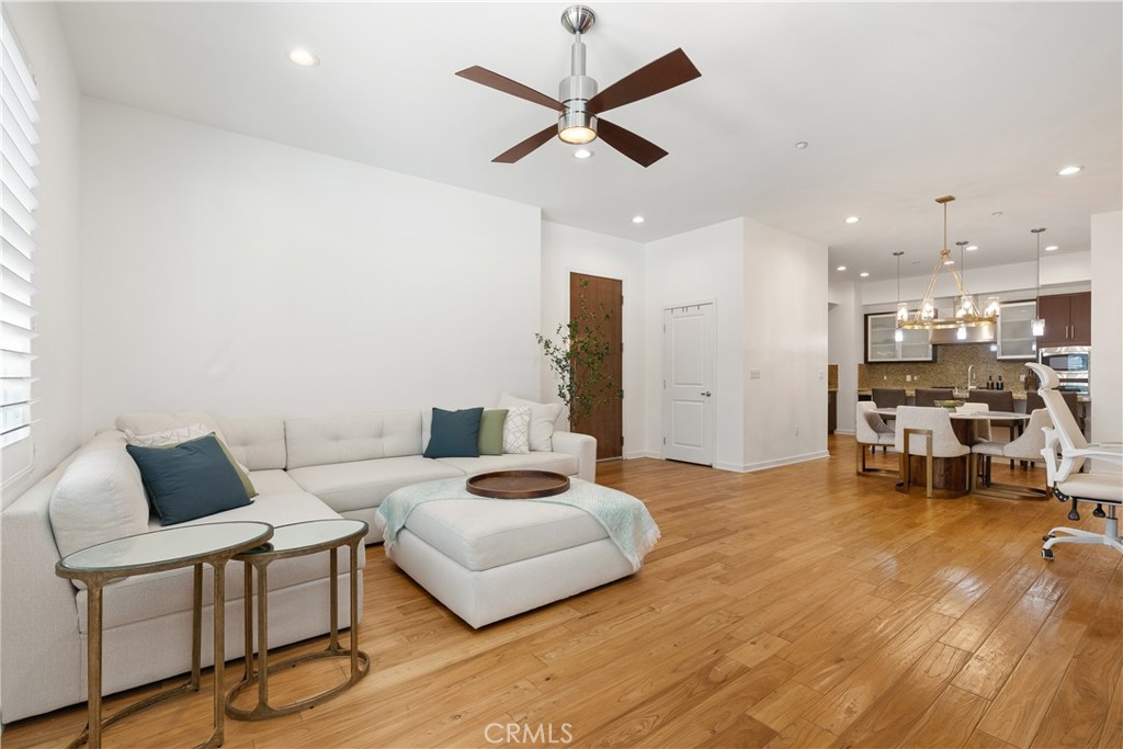 Modern living room featuring contemporary finishes, sleek ceiling fan, and an airy open layout. - 21 Gramercy 102, Irvine CA 92612 - photo 6