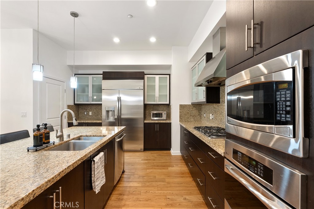 Chef inspired kitchen featuring stainless steel appliances, oversized island, and abundant storage. - 21 Gramercy 102, Irvine CA 92612 - photo 8