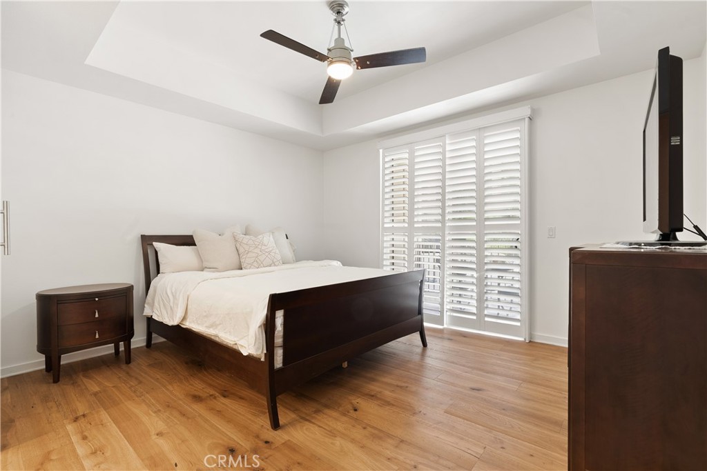 Spacious primary suite with large windows, balcony access, designer touches, and relaxing ambiance. - 21 Gramercy 102, Irvine CA 92612 - photo 15