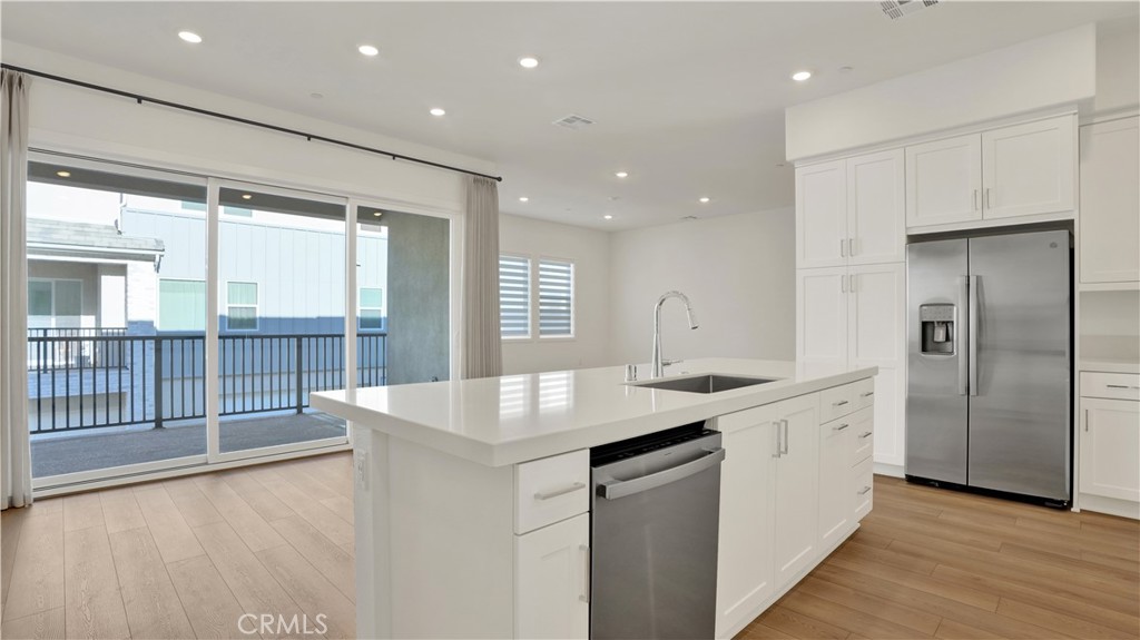 Welcome home. Living area boasting a beautiful quartz island, wood flooring, sliding glass doors to a outdoor patio. - 236 Knot, Irvine CA 92618 - photo 1