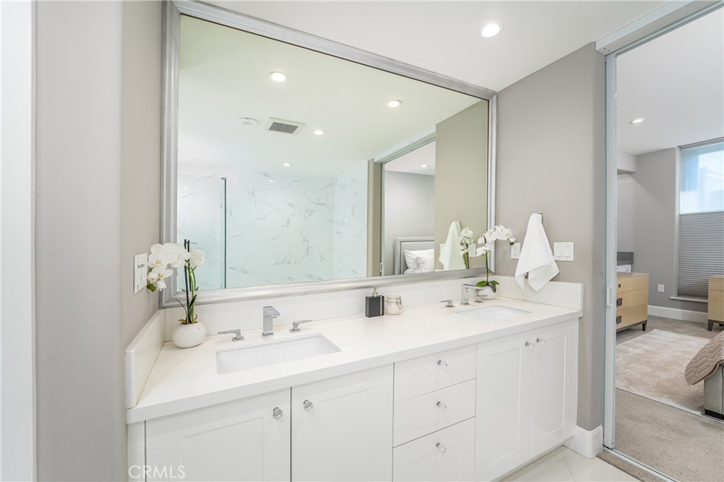 Remodeled primary bath with heated floors, dual sink vanity, separate jetted tub and shower, and doors to the bedroom ad - 3043 Scholarship, Irvine CA 92612 - photo 22