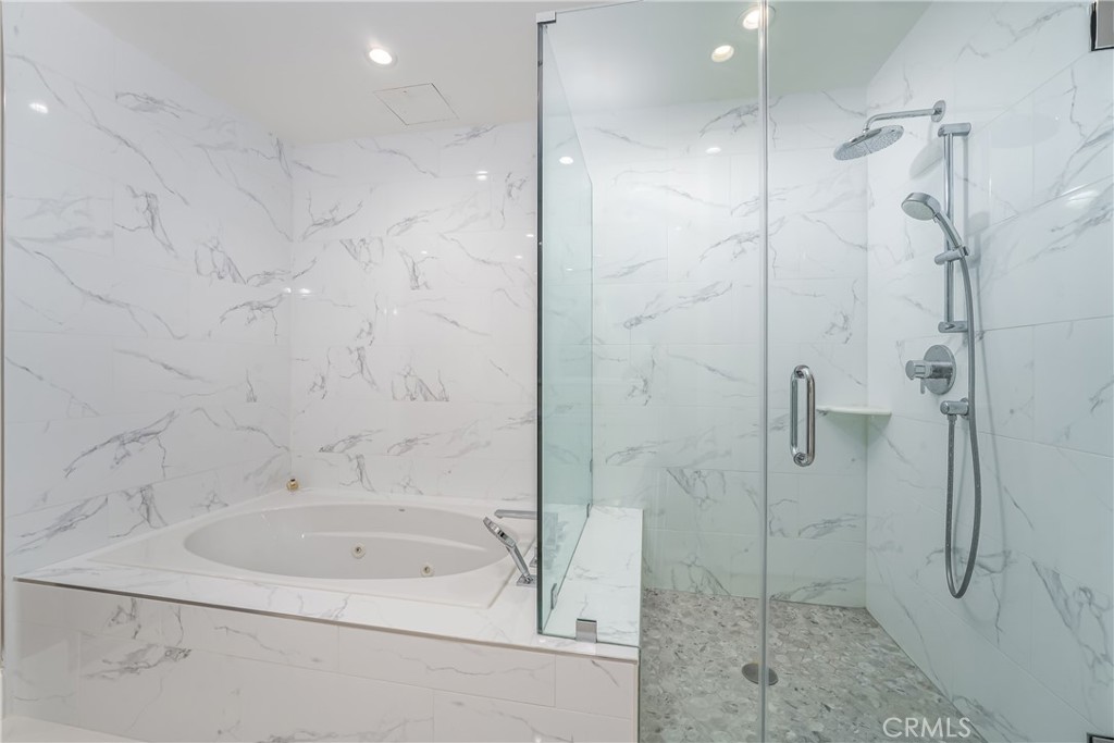 Remodeled primary bath with heated floors, dual sink vanity, separate jetted tub and shower, and doors to the bedroom ad - 3043 Scholarship, Irvine CA 92612 - photo 23