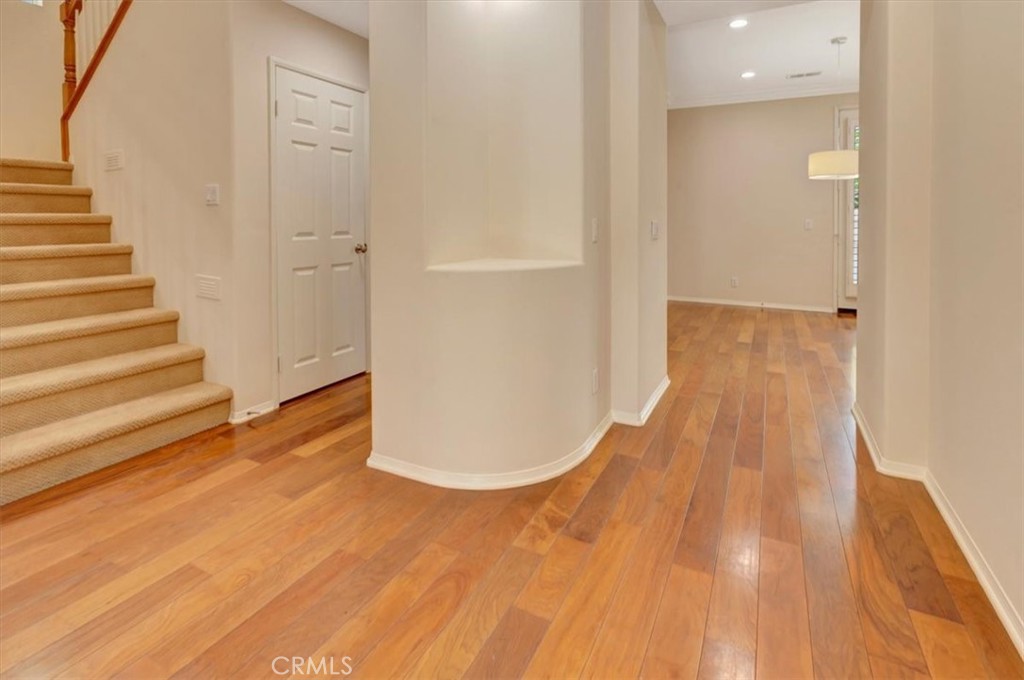 Central hallway with coat closet (wraps under stairs for plenty of storage) right leads to spacious dining room adjacent - 47 Canopy, Irvine CA 92603 - photo 6