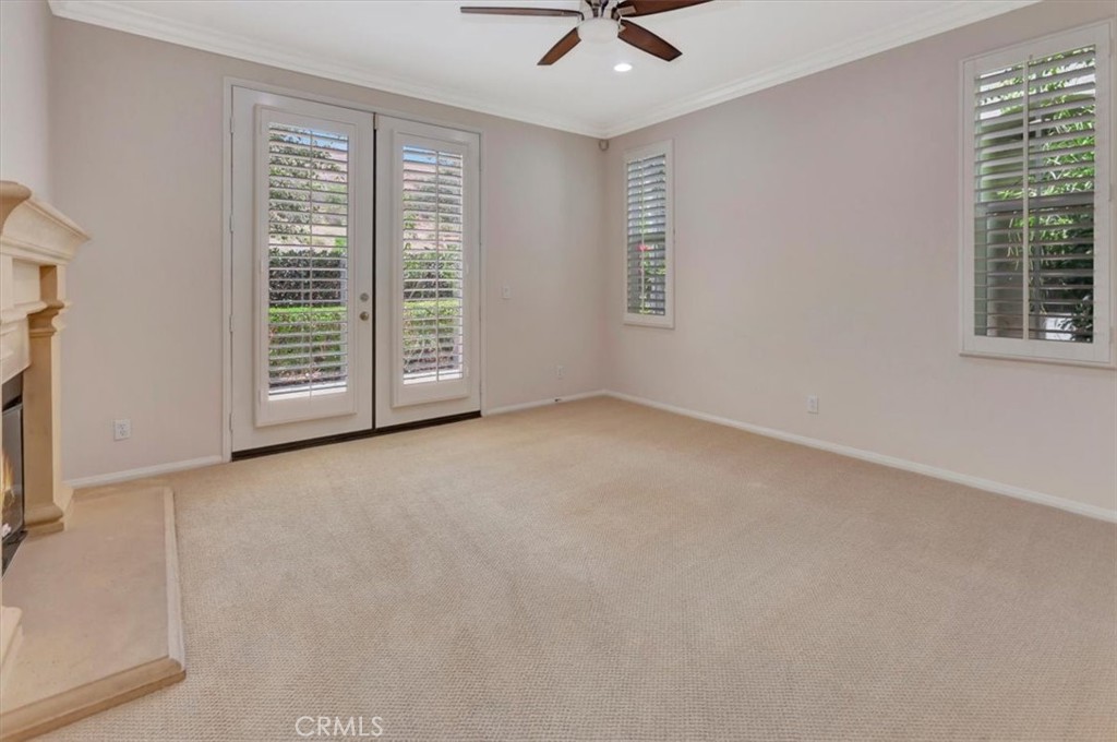 Plantation shutters living room cozy fireplace, French doors to front tranquil patio and serene view - 47 Canopy, Irvine CA 92603 - photo 7