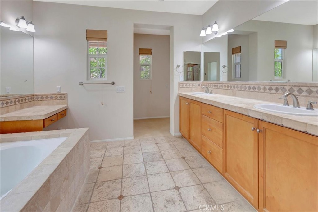 Primary bathroom with soaking tub, dressing table to the left, dual sinks and mirror to let in more light! - 47 Canopy, Irvine CA 92603 - photo 20