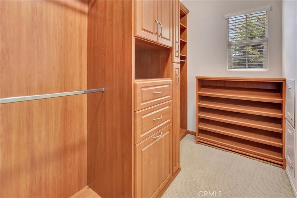 Primary walk-in closet with lots of organizers, shoe rack, laundry bin - 47 Canopy, Irvine CA 92603 - photo 21