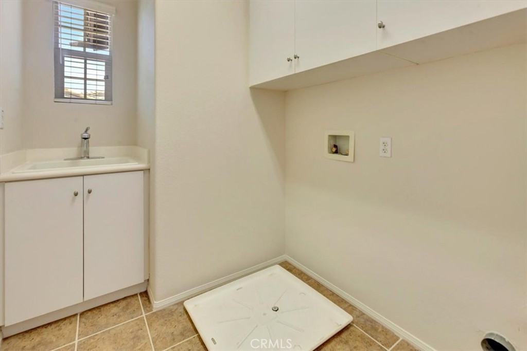 Separate laundry room with rinse sink and storage cabinets - 47 Canopy, Irvine CA 92603 - photo 27