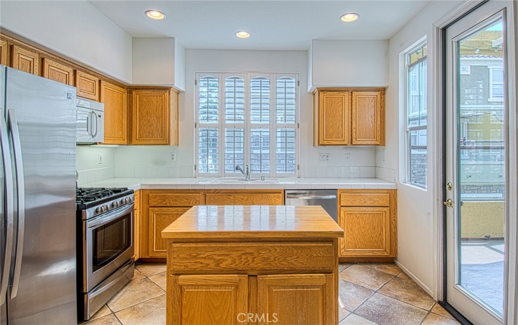 Kitchen with center island opens to balcony. - 808 Terra Bella, Irvine CA 92602 - photo 2