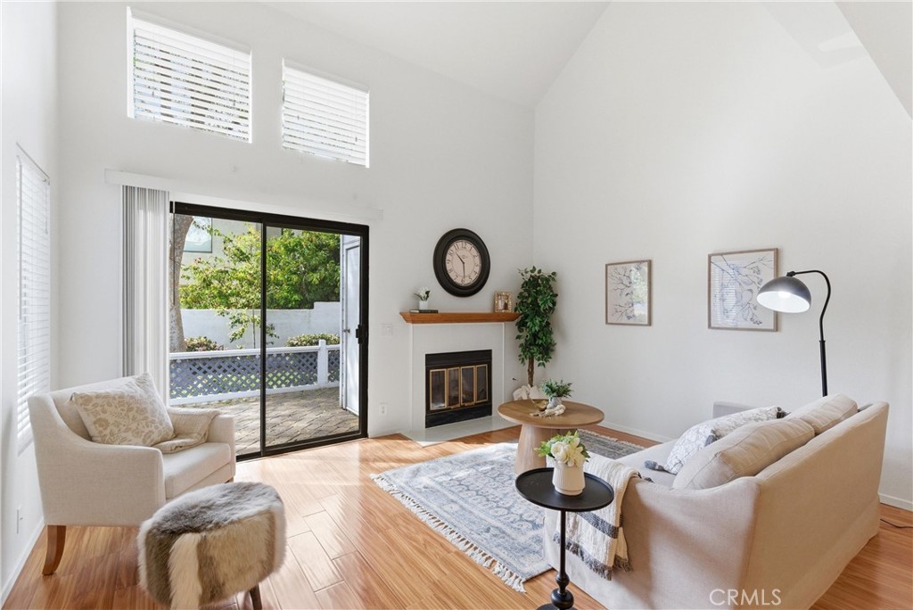 The living room space is open and airy with a 2-story ceiling and cozy gas fire. - 81 Briarglen, Irvine CA 92614 - photo 1