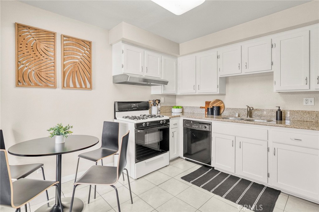 Interior features include newer paint and flooring, along with an upgraded kitchen showcasing new cabinetry, granite cou - 1064 Las Lomas Drive D, La Habra CA 90631 - photo 9