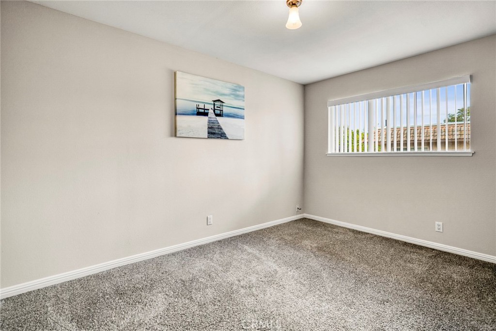 The secondary bedroom features comfortable carpeting, creating a cozy and inviting space ideal for guests, family member - 1064 Las Lomas Drive D, La Habra CA 90631 - photo 17
