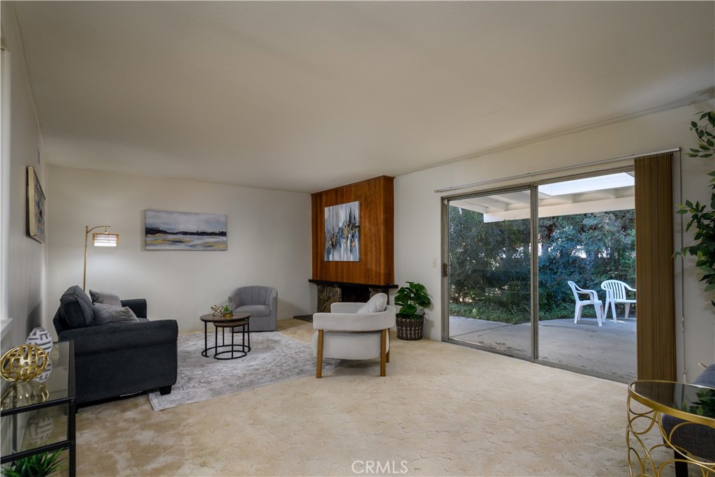 Living room with a fireplace and sliding glass door to the back yard - 1301 Ironwood Street, La Habra CA 90631 - photo 8