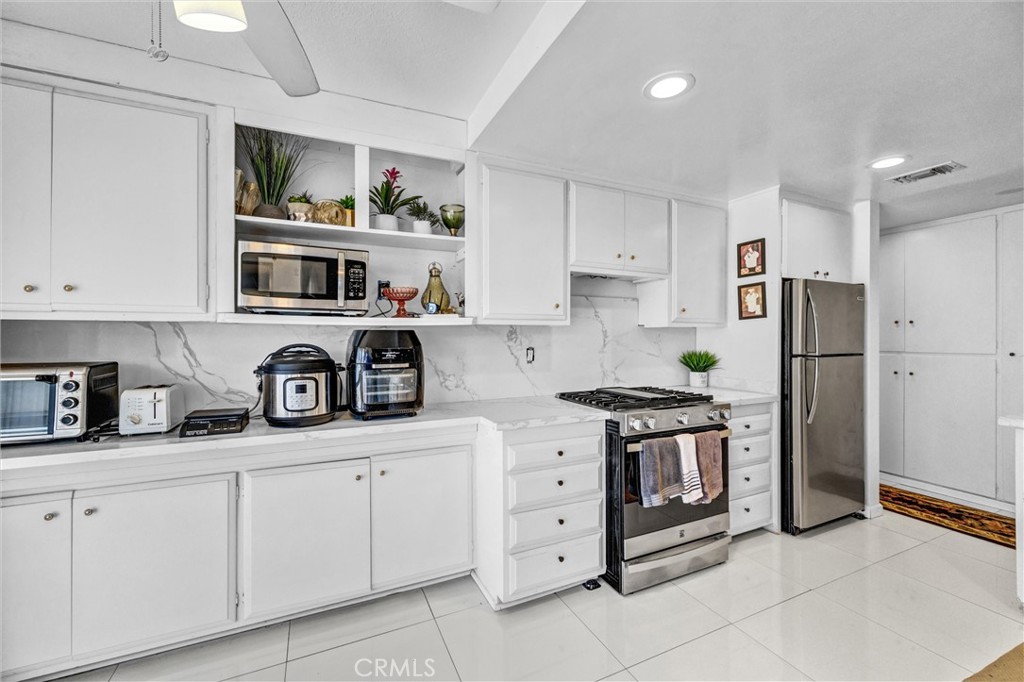Bright, open kitchen with a breakfast bar, recessed lighting, and sliding glass doors overlooking the backyard - 919 Glencliff, La Habra CA 90631 - photo 4