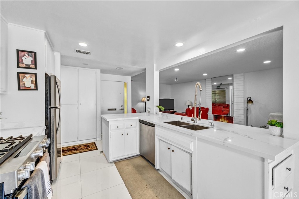 Spacious kitchen with tile flooring, a breakfast bar, and an open view into the living area. - 919 Glencliff, La Habra CA 90631 - photo 6
