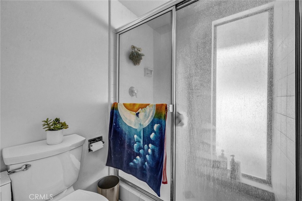 Walk-in shower with sliding glass enclosure, tiled walls, and a frosted window for natural light and privacy. - 919 Glencliff, La Habra CA 90631 - photo 9