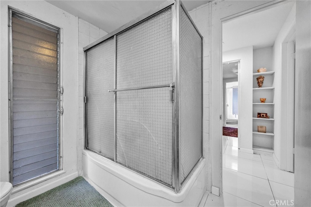 Guest bathroom featuring a tub and shower combination with sliding glass enclosure and natural light. - 919 Glencliff, La Habra CA 90631 - photo 12