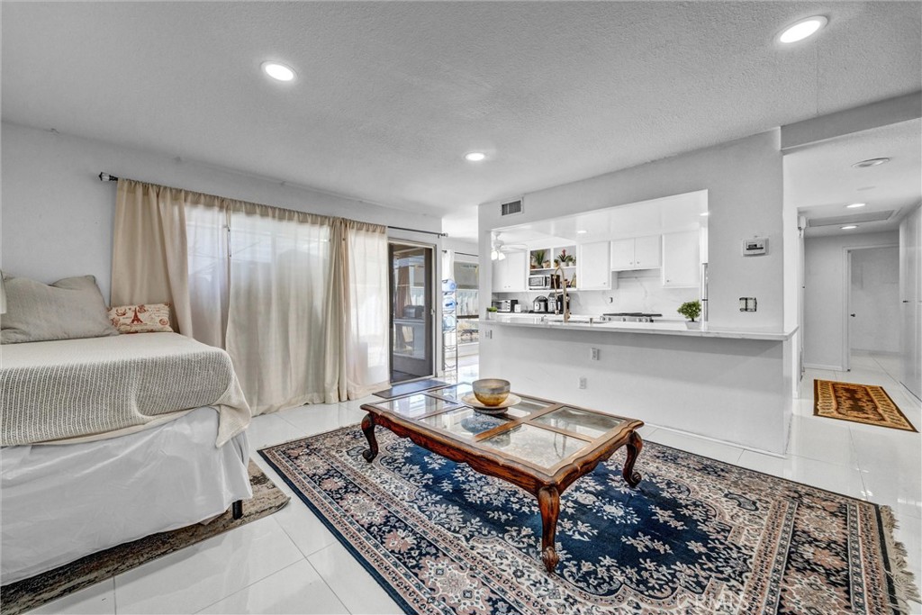 Spacious living area with tile flooring, recessed lighting, and an open view of the remodeled kitchen. - 919 Glencliff, La Habra CA 90631 - photo 18