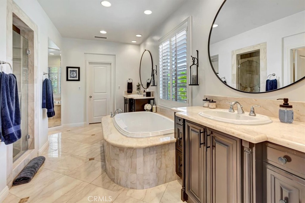 Exquisitely appointed primary bathroom featuring marble finishes and premium fixtures. - 15 Julia Street, Ladera Ranch CA 92694 - photo 28