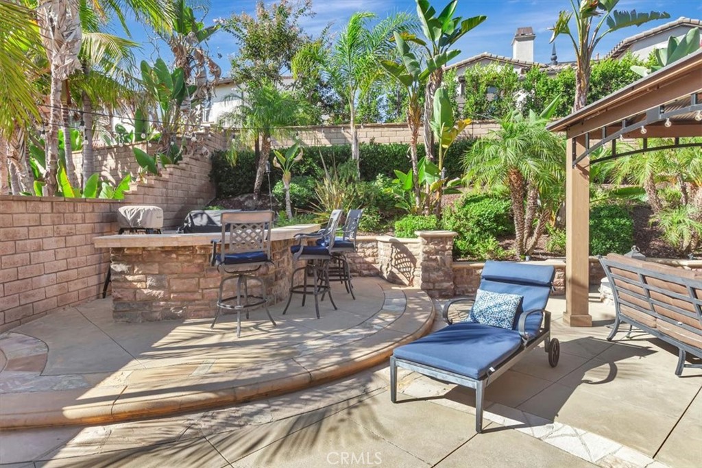 Outdoor kitchen area featuring a built-in barbecue grill and bar seating. - 15 Julia Street, Ladera Ranch CA 92694 - photo 41