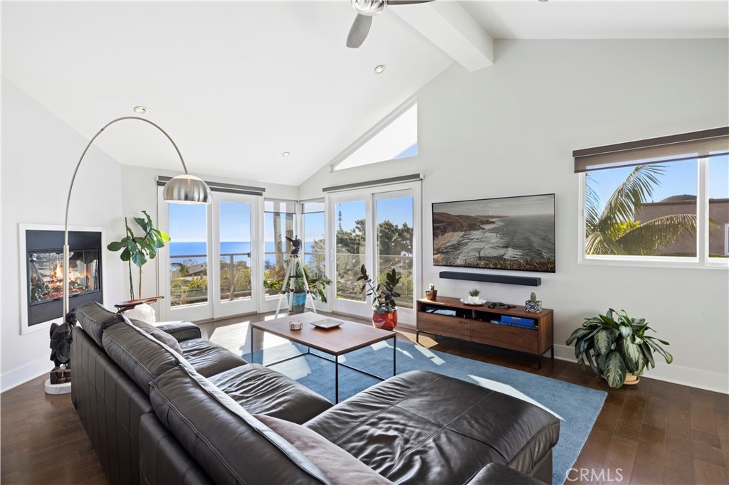 Upstairs, vaulted ceilings soar over a living room with ocean views that displays a fireplace and wraparound deck. - 1075 Noria, Laguna Beach CA 92651 - photo 1