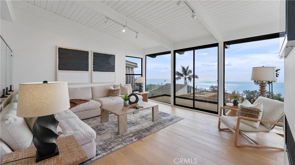 Light-filled living room with an open and airy feel, showcasing ocean and white-water views - 1095 Miramar, Laguna Beach CA 92651 - photo 7
