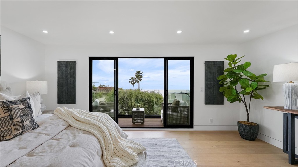 Comfortable primary bedroom with a peaceful atmosphere, ocean views, and balcony access. - 1095 Miramar, Laguna Beach CA 92651 - photo 25