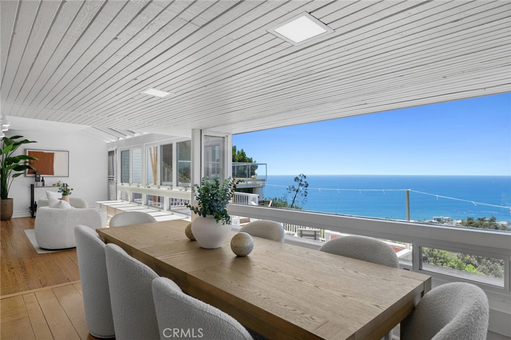 Spacious living and dining areas face the Pacific, framed by expansive walls of glass that invite the outdoors in and pr - 1105 Summit Drive, Laguna Beach CA 92651 - photo 10