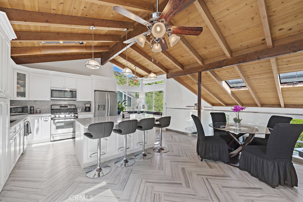 Open kitchen and dining area boasts soaring wood beamed ceilings with skylights, porcelain plank flooring, Quartz counte - 1165 Keller Way, Laguna Beach CA 92651 - photo 1
