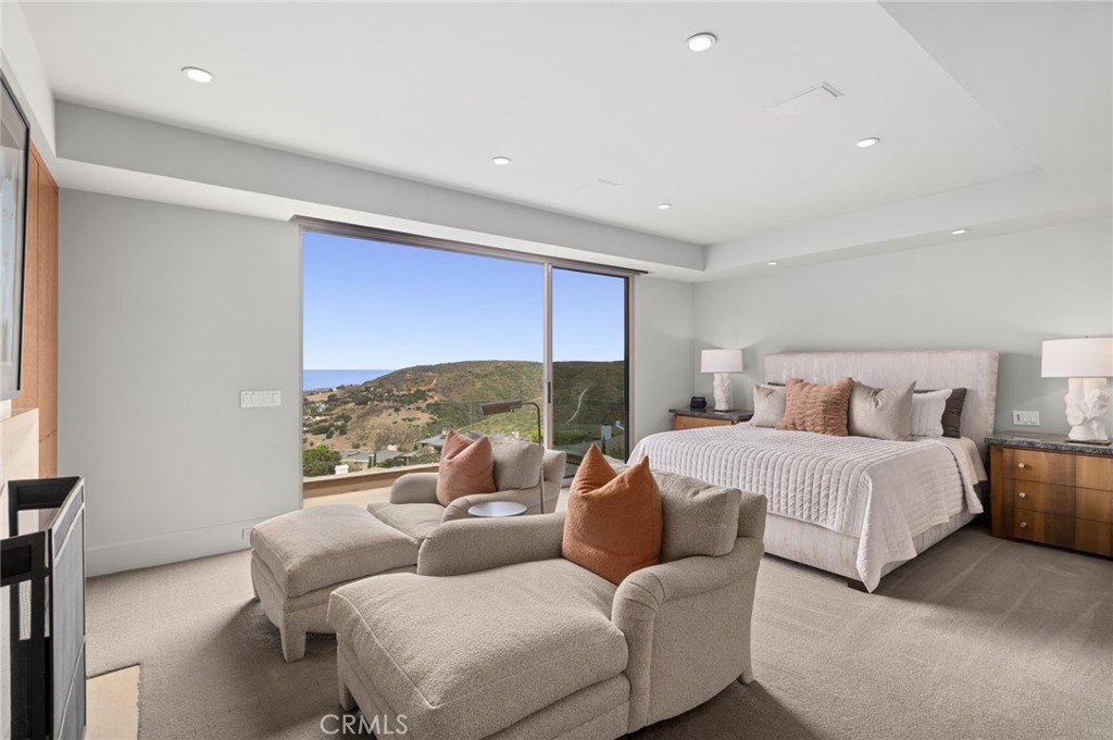 The primary suite on the main level offers ocean-view deck access, a fireplace, walk-in closets,. - 1409 Samoa Way, Laguna Beach CA 92651 - photo 19