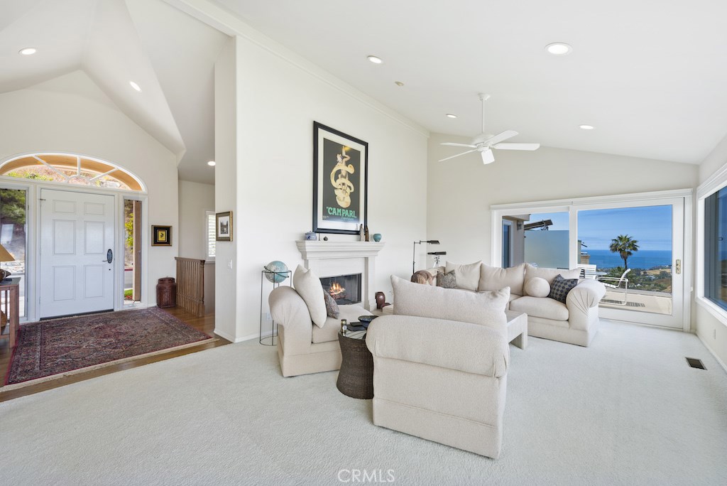 The living room with soaring vaulted ceilings includes a cozy gas fireplace, and formal entry to the left. - 1455 Skyline Drive, Laguna Beach CA 92651 - photo 1