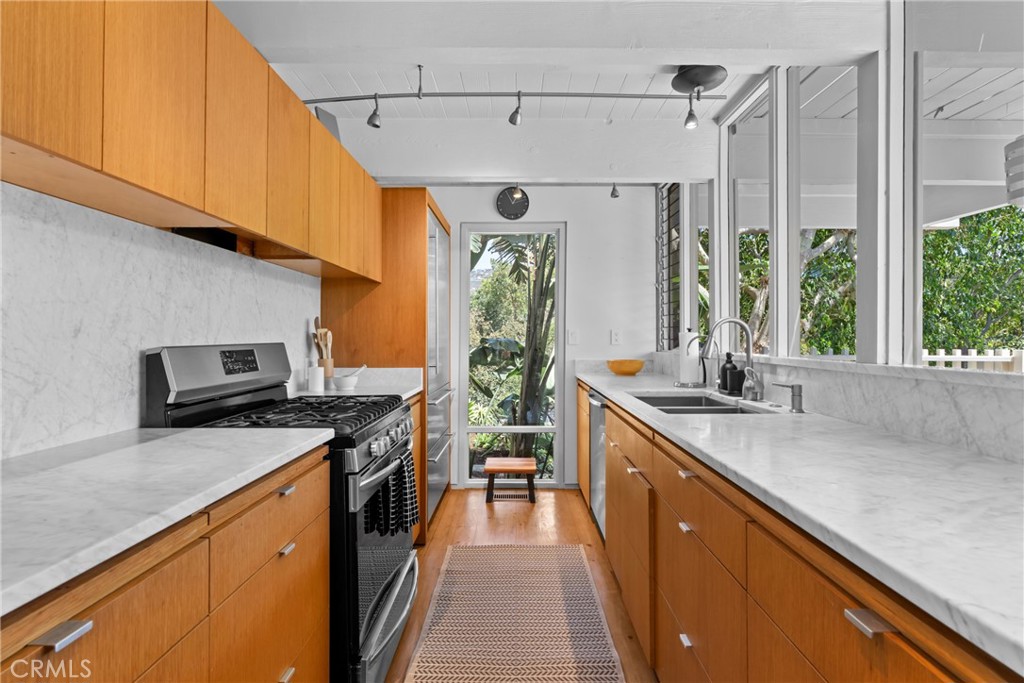 kitchen with quartz counter tops, gas stove, dishwasher, disposal, and refrigerator - 1494 Bluebird Canyon Drive, Laguna Beach CA 92651 - photo 16
