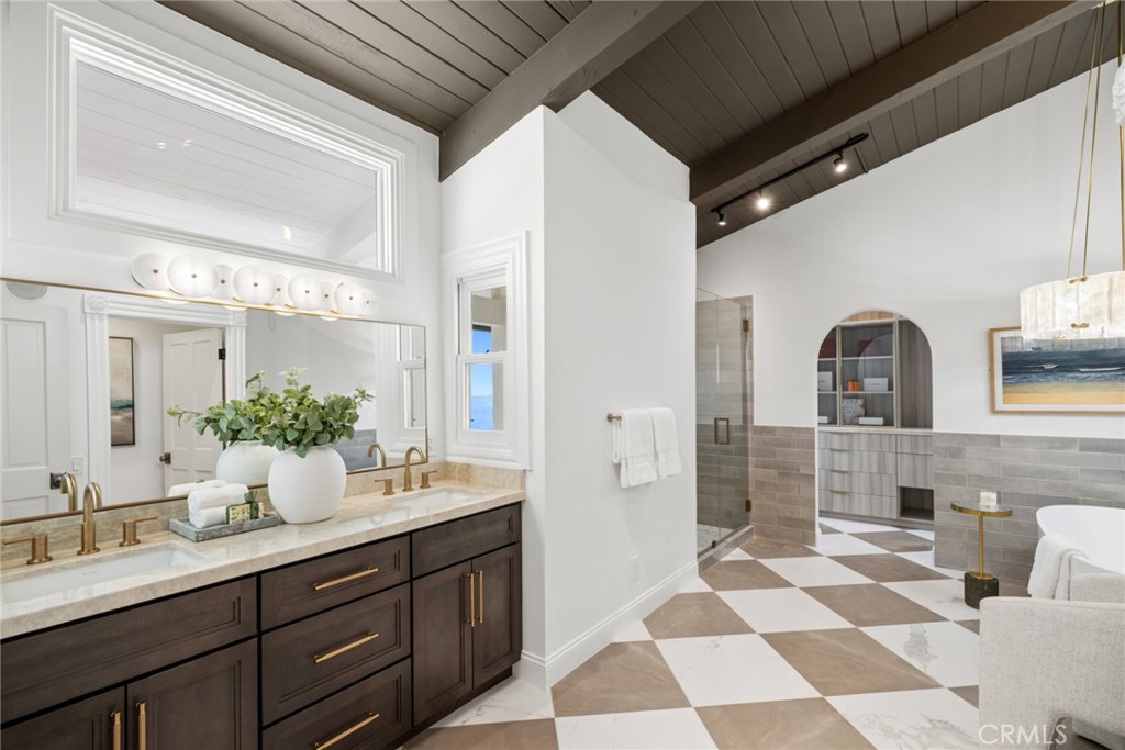 The primary suite serves as a private retreat, offering ocean views, direct access to a private deck, and a spa-inspired - 1675 Tahiti Avenue, Laguna Beach CA 92651 - photo 22
