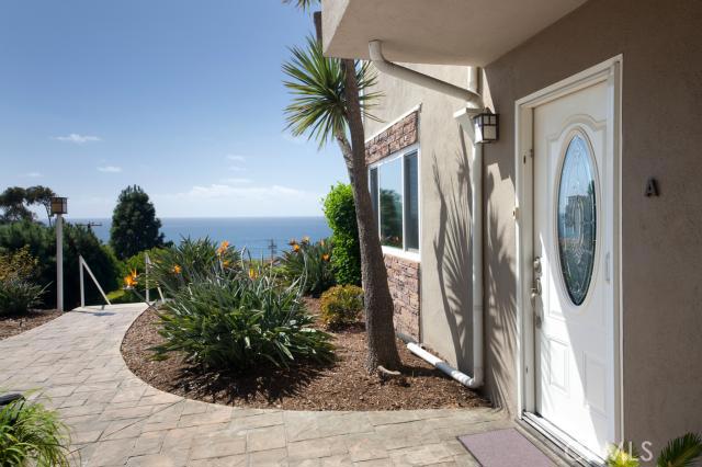 Entry walkway with newer pavers. Custom front door. - 21701 Wesley Drive A, Laguna Beach CA 92651 - photo 1
