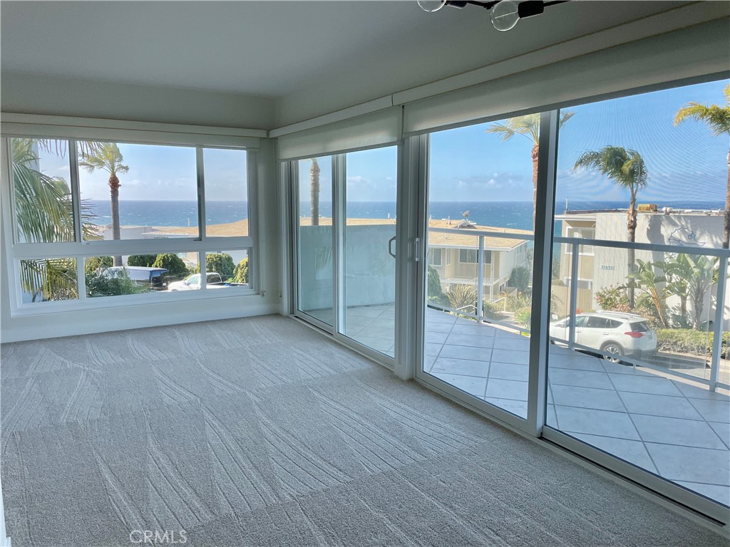 Corner windows allow for natural light all day. 2 Sliding doors open to deck for indoor outdoor living. - 21703 Ocean Vista Drive 202-A, Laguna Beach CA 92651 - photo 1