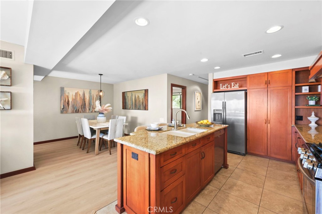 A view of the open remodeled kitchen, the kitchen island with seating for 2 and the dining room beyond. - 21771 Ocean Vista Drive 29, Laguna Beach CA 92651 - photo 5