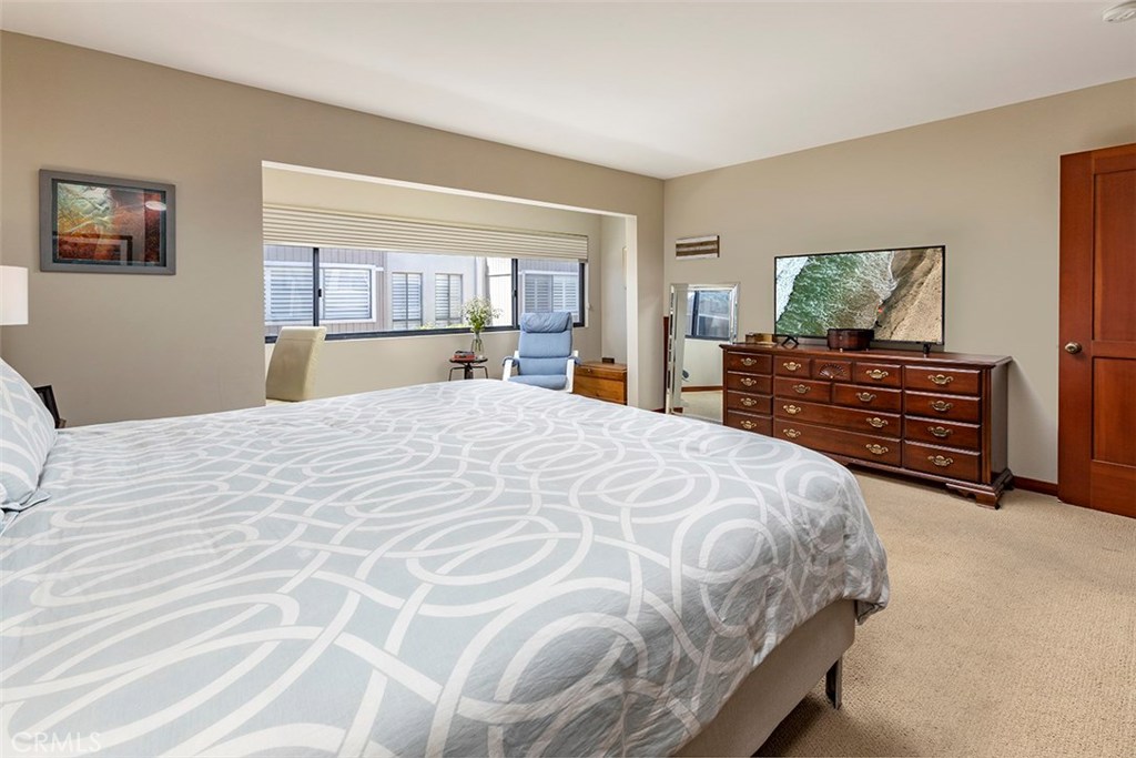 A view of the large primary bedroom suite from the bathroom, the alcove is frequently used as an office space. - 21771 Ocean Vista Drive 29, Laguna Beach CA 92651 - photo 19