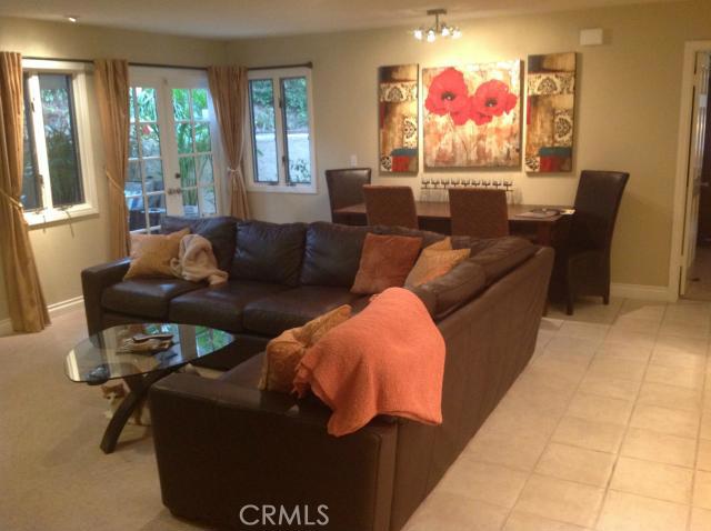 Living room with French doors opening to the patio - 247 Calliope Street 3, Laguna Beach CA 92651 - photo 1