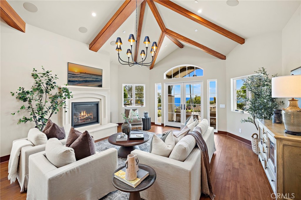 Living room with soaring ceilings and distressed maple hardwood flooring that extends throughout the home, complemented - 3002 Dorn Court, Laguna Beach CA 92651 - photo 5