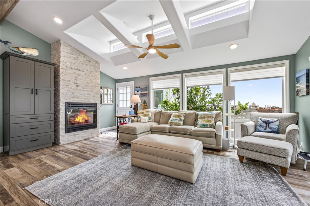 View of living area showing storage cabinet, fireplace, skylights, flooring - 30802 S Coast Highway F-10, Laguna Beach CA 92651 - photo 3