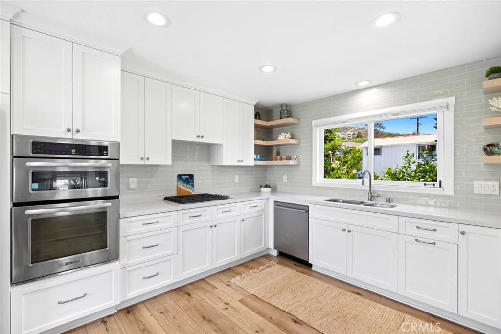 Appointed with stainless steel appliances, quartz countertops, a subway tile backsplash, and a pantry with pull-out shel - 31012 Aliso Circle, Laguna Beach CA 92651 - photo 9
