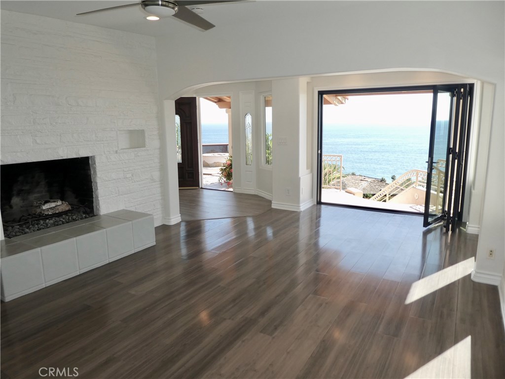 Updated folding door now installed! The spacious living room has panoramic ocean and white water crashing wave views, in - 31122 Brooks Street, Laguna Beach CA 92651 - photo 13